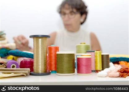 the reels of colored threads, seamstress at the bottom