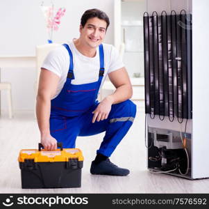 The repairman contractor repairing fridge in diy concept. Repairman contractor repairing fridge in DIY concept