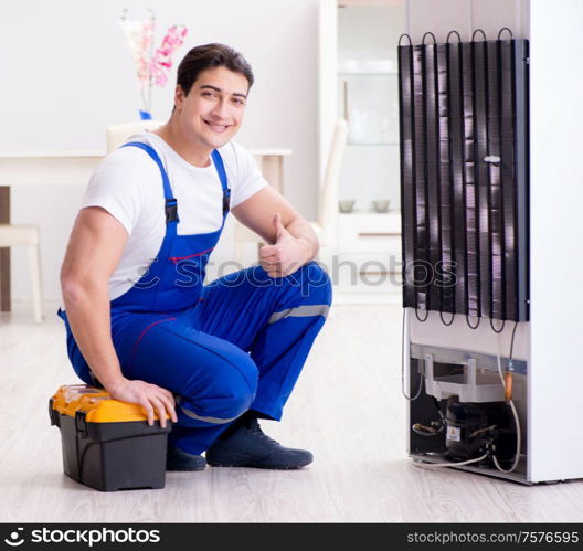 The repairman contractor repairing fridge in diy concept. Repairman contractor repairing fridge in DIY concept