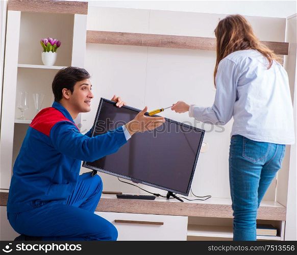 The repairman repairing tv at home. Repairman repairing tv at home