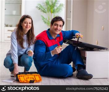 The repairman repairing tv at home. Repairman repairing tv at home