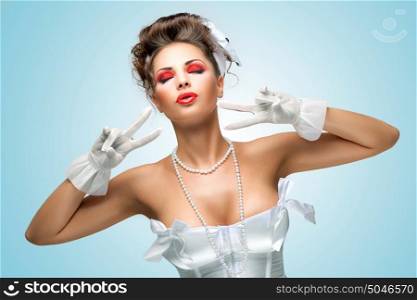The retro photo of a glamorous bride with stylish makeup in a vintage corset showing V sign.