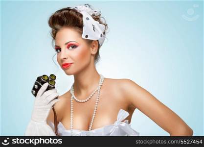 The retro photo of a glamorous pin-up girl with an old vintage cinema 8 mm camera.