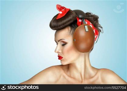 The retro photo of cute girl in vintage headphones listening to the music.