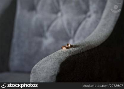 The rings are on the chair.. Wedding rings on the armrest of a velour armchair 3901.