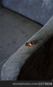 The rings are on the chair.. Wedding rings on the armrest of a velour armchair 3902.