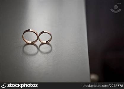 The rings of the newlyweds are rolling on the table.. The rings of the newlyweds standing on the end of the table 4258.