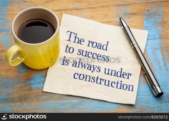 The road to success is always under construction - handwriting on a napkin with a cup of espresso coffee