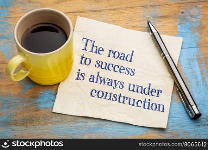 The road to success is always under construction - handwriting on a napkin with a cup of espresso coffee