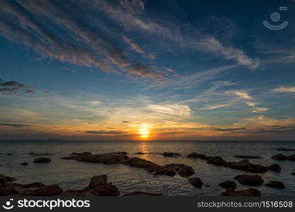 The rock on the sea with sunset sky