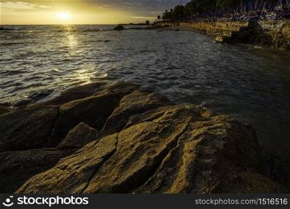 The rock on the sea with sunset sky