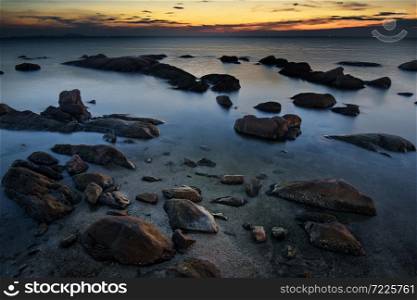 The rocks on the sea with sunset sky