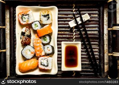 The rolls and sushi plate with soy sauce on a tray.. The rolls and sushi plate with soy sauce