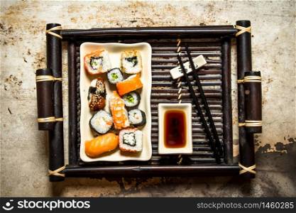 The rolls and sushi plate with soy sauce on a tray.. The rolls and sushi plate with soy sauce