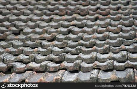 The roof of an old house covered with gray tiles.. The roof of an old house covered with gray tiles