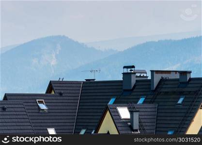 The roof of the villa is close-up against the backdrop of the mo. The roof of the villa is close-up against the backdrop of the mountains covered with forest