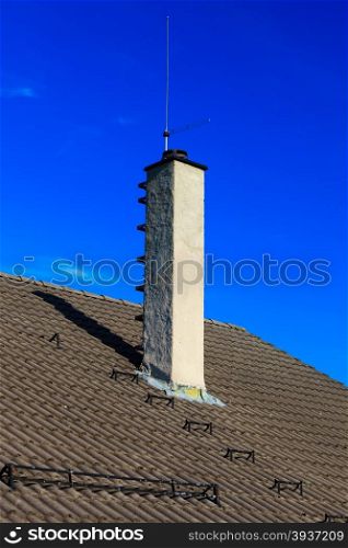 The roofing tiles house roof with chimney and safety metal ladder to climb sky background