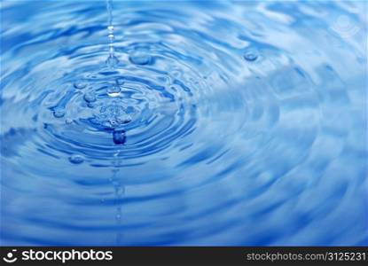 The round transparent drop of water falls downward