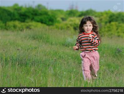 The running girl on a green floor. The happy child on a spring meadow