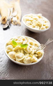 The Russian national dish - Pelmeni. Dumplings with meat, spiced with pepper  and butter