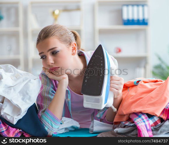 The sad woman ironing clothing at home. Sad woman ironing clothing at home