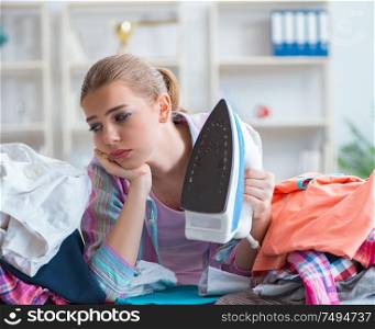 The sad woman ironing clothing at home. Sad woman ironing clothing at home