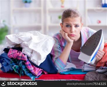 The sad woman ironing clothing at home. Sad woman ironing clothing at home