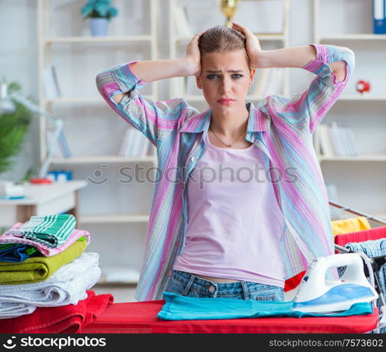 The sad woman ironing clothing at home. Sad woman ironing clothing at home