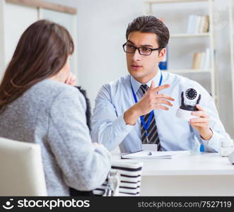 The sales assistant showing cameras to client in shop. Sales assistant showing cameras to client in shop