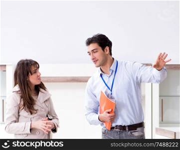 The salesman explaining to woman customer at furniture store. Salesman explaining to woman customer at furniture store