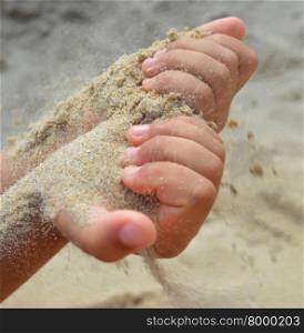 The sand flows out of the hands