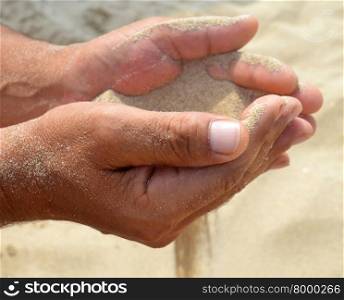The sand flows out of the palms