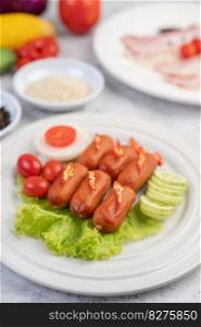 The sausage is put on a white plate with chili, tomatoes, cucumbers and salad greens.