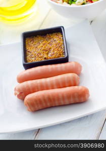 The sausages with the mustard, sausages in white plate