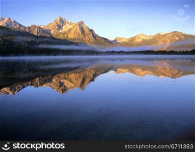 The Sawtooth Mountains on a misty morning have a mirror-like reflection in Stanley Lake, in northern Idaho&acute;s Sawtooth wilderness area