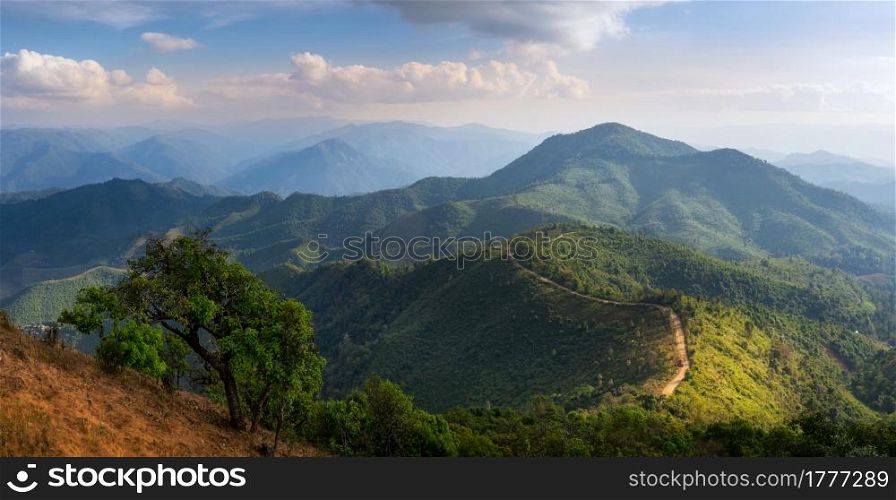 The scenic landscape of high mountains in the evening with lonely tree foreground, on top viewpoint mountain Doi Pui Cu, Popular tourist attraction in Mae Hong Son, Thailand.. Landscape of Doi Pui Co.