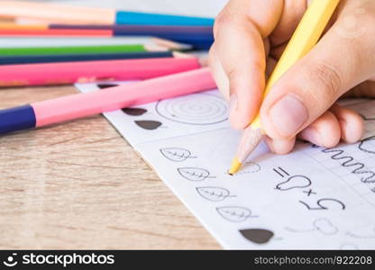 The schoolboy draws with a pencil in a notebook. Pencil in the hands of children. The boy is drawing.. The schoolboy draws with a pencil in a notebook. Pencil in the hands of children.