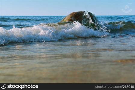 the sea wave breaks on the rocks, the sea wave hits the shore. the sea wave hits the shore, the sea wave breaks on the rocks