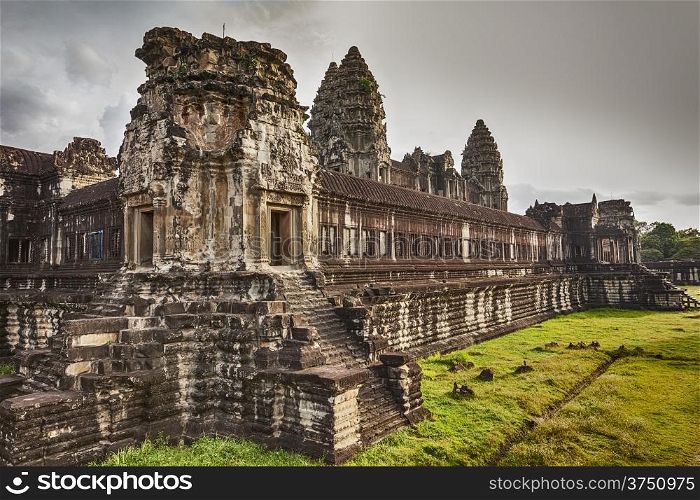 The second of three courtyard walls of Angkor Wat showcases the ancient Khmer architecture. Three of the central towers are visible over the walls.
