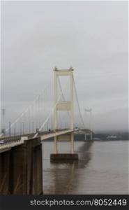 The Severn Bridge (welsh Pont Hafren) crosses from England to Wales across the rivers Severn and Wye. Misty morning view from England side.