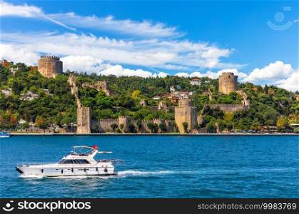 The ship sails in the Bosphorus strait by Rumeli Hisari castle, Istanbul.