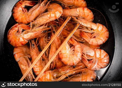 The shrimp are cooked in a pot of water. Macro background. High quality photo. The shrimp are cooked in a pot of water.