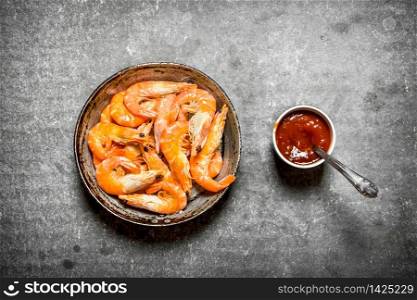 The shrimp in the pan with the sauce. On the stone table.. The shrimp in the pan with the sauce.