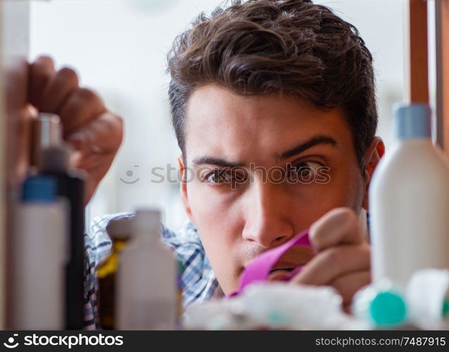 The sick ill man looking for medicines at farmacy shelf. Sick ill man looking for medicines at farmacy shelf