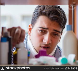 The sick ill man looking for medicines at farmacy shelf. Sick ill man looking for medicines at farmacy shelf