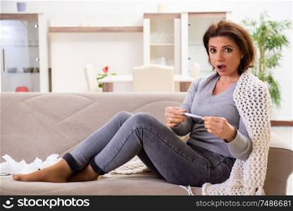 The sick middle-aged woman suffering at home . Sick middle-aged woman suffering at home