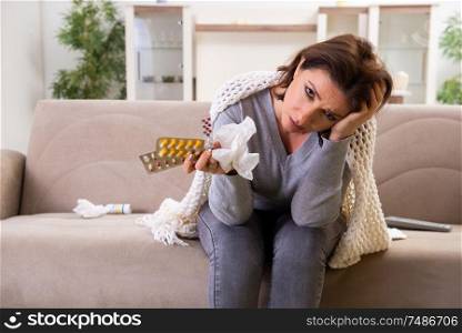 The sick middle-aged woman suffering at home . Sick middle-aged woman suffering at home