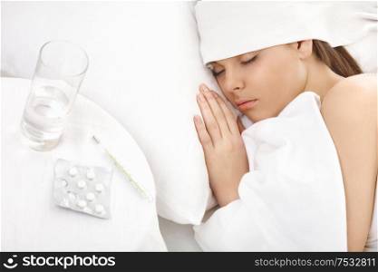 The sick woman sleeps in beds, nearby medicines