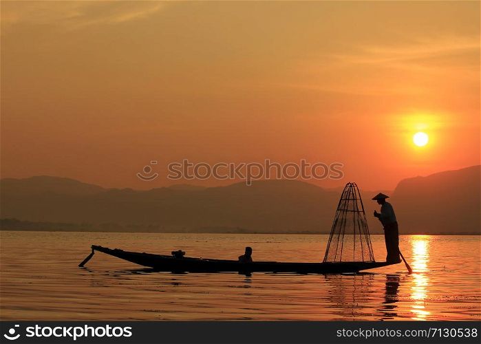 The silhouette of a fisherman on the lake