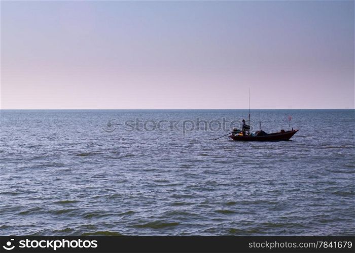 The silhouette of a fisherman with his boat in the sea